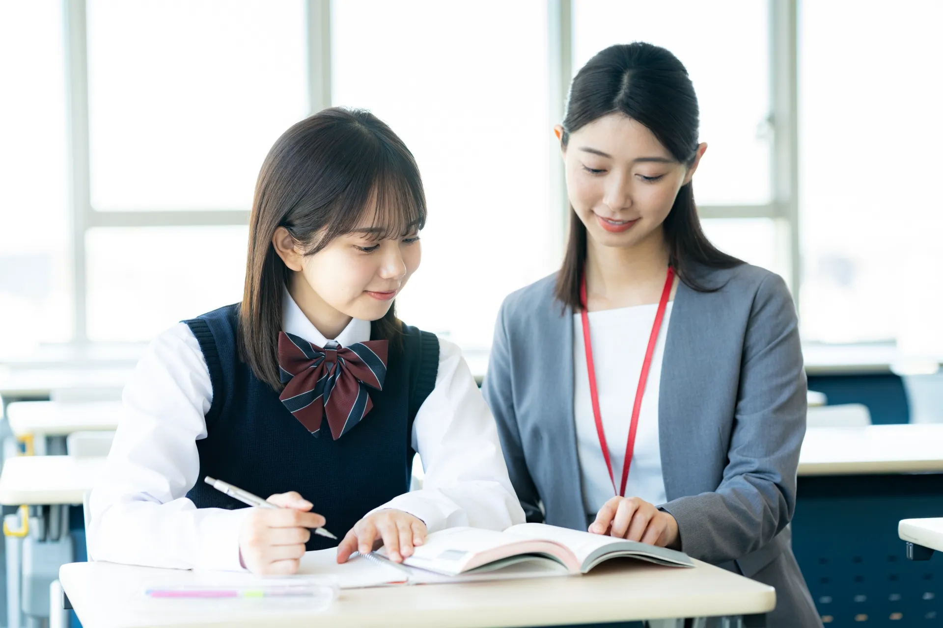 学校で授業中に話している先生と生徒の写真